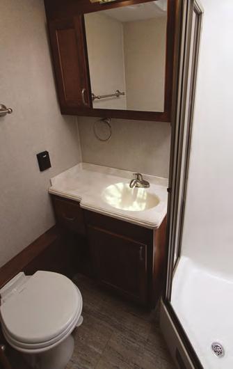 COACH FEATURE RENEGADE VALENCIA A porcelain toilet, a hardwood vanity with a solid-surface top, and a fiberglass shower stall outfit the Valencia s bathroom.