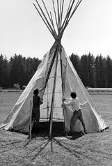 Using short pieces of rope or strips of cloth (a belt will do), bind the tipi cover to the lift pole