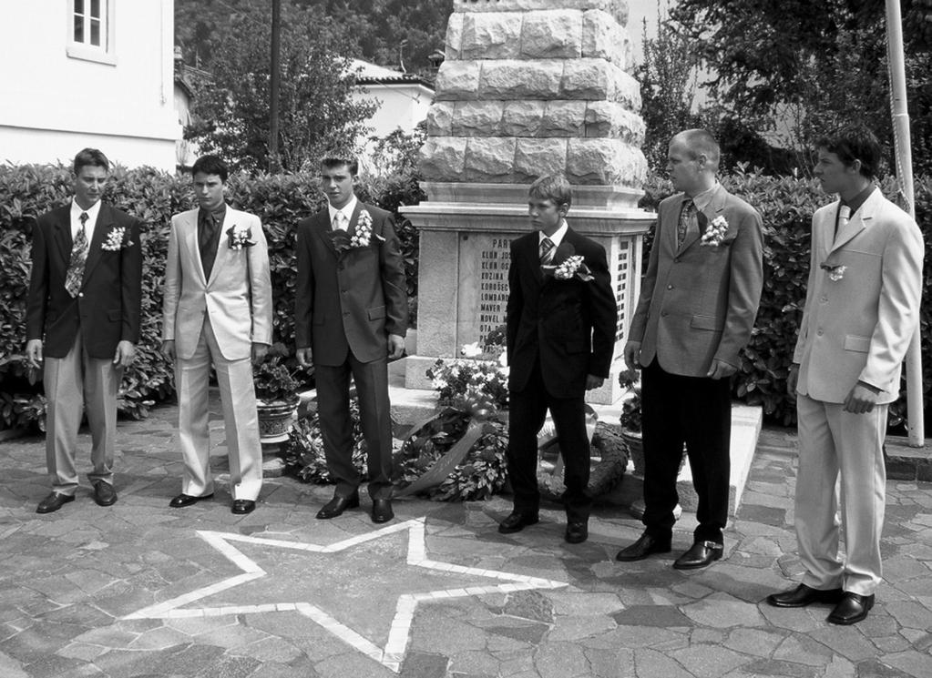 Slika 2: Boljunska fantovska pred spomenikom NOB. Dva "gvardjana" (levo in desno), trije mladi fantje in ŽPN (župan). Bagnoli della Rosandra/Boljunec, 1. 5. 2000. (foto: J.