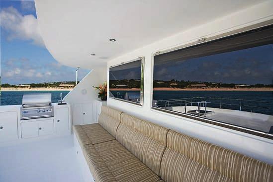 Just past the salon s electric glass and stainless steel sliding doors, on the starboard side is a wet bar and a plush L-shaped sofa, facing a coffee table.