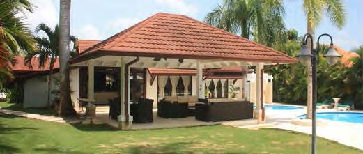 A sandstone terrace, dotted with loungers, connects to a furnished gazebo where ample