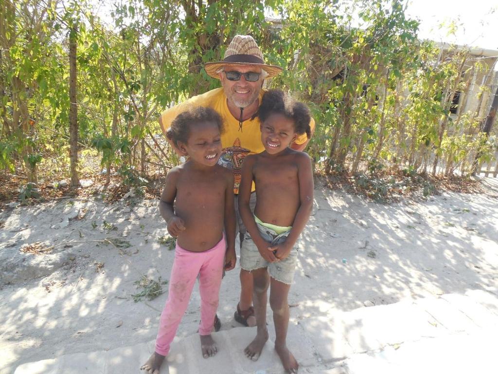 I pose with two indigenous children who were