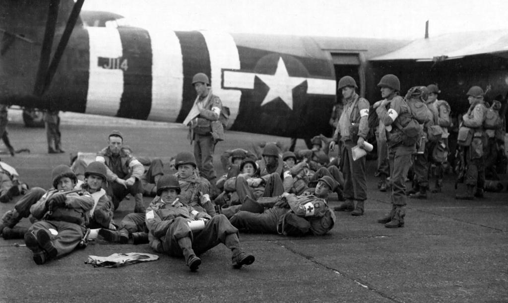 Hastily applied invasion stripes greet this somber group of airborne infantry as they ready to board a Horsa glider for their June 6 daylight delivery to Normandy.