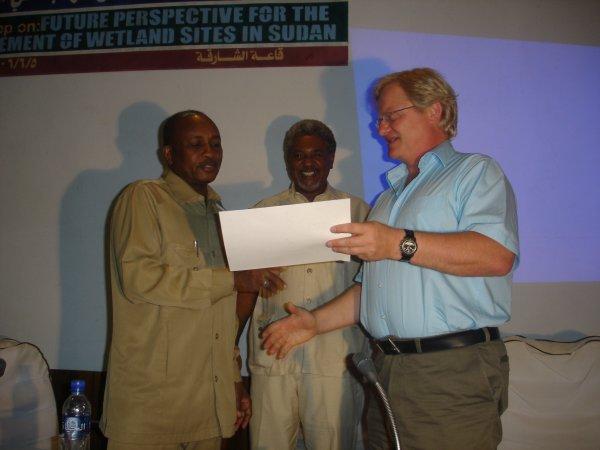 The representative of WWF International (right) presenting the Ramsar site certificate for the Sudd marshes designation on behalf of Abou Bamba,