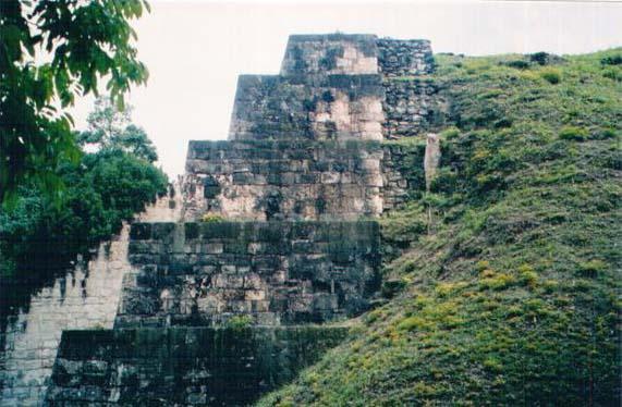 Piramida dijelom oteta ispod brda, Tikal, Guatemala Put ka istocnom obodu Tikal-a je pust. Mir narusavaju moji koraci i udar plodova o tle sa stoljetnih stabala.