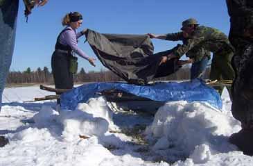 ) Closed Shelter without Fire Students during a winter survival course busy at work building a winter snow trench shelter.