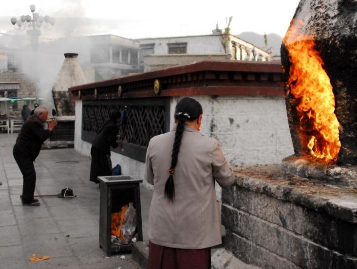 At gray dawn, Tibetans stoking fires with willow branches in