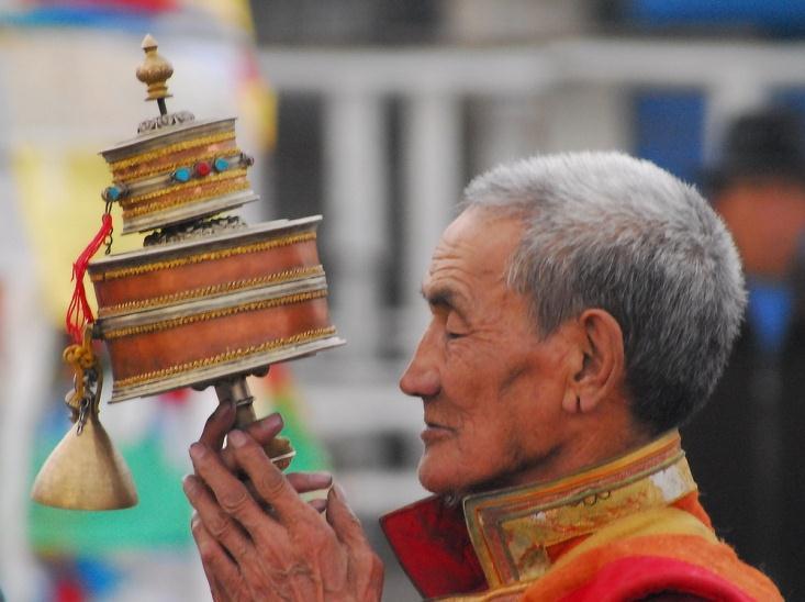 Meditating with prayer wheel at dawn in Jokhang, Lhasa This photo was selected for
