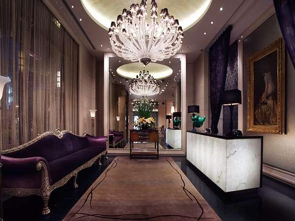 Reception area, decorated with a plush velvet sofa, drapes and vast glass hanging light