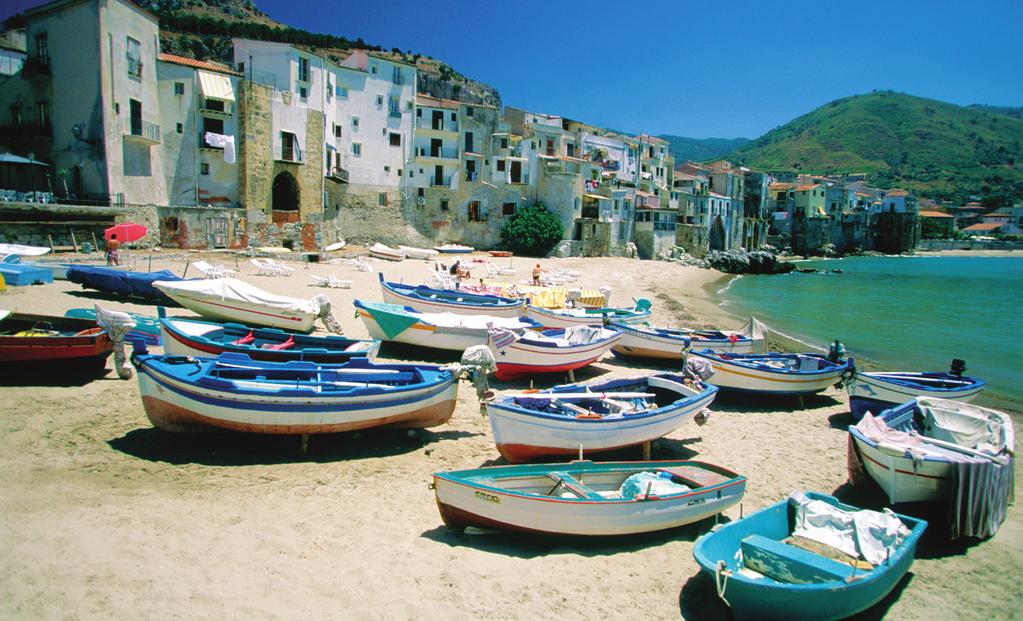 Colorful fishing boats along a Sicilian harbor highlight: lunch at a family-run working farm amidst acres of lemon and kiwi.
