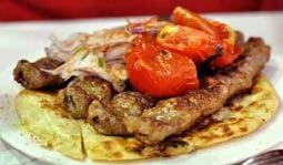 The famous gyros and souvlaki, the traditional Greek fast food, consists of pork meat, French fries, tomato, onions and tzatziki,