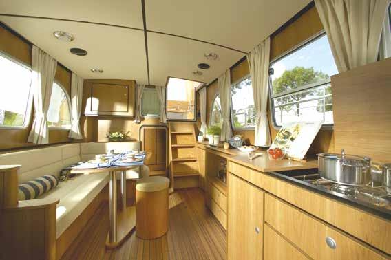 Spacious saloon/ galley with convertible dinette and writing desk.