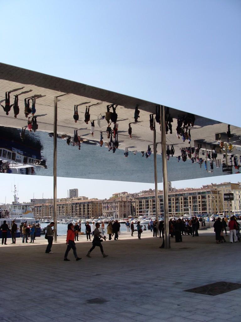 polished stainless steel canopy amplifies and reflects the surrounding movement of the harbor, creating a spectacle that encourages pedestrians to stop