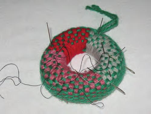 Volneni miniaturni svitek iz Bohinja za shranjevanje igel. A woollen miniature headcushion from Bohinj for storing needles.
