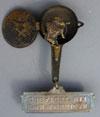 Lot # 103 - Mechanical Brass Hanging Badge with "Pan-American Greatest Hit" written on the top bar.