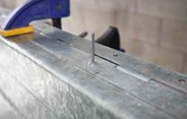 Use heavy duty rivets. Fix the hinge to the trailer with heavy duty rivets.