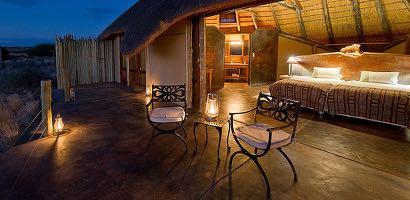 Doro Nawas Camp comprises 16 units: a mix of stone and canvas walls with wood and glass doors, shaded by a thatch roof.