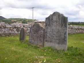 headstones, facing southwest The site is located in the south western corner of a large field in a rural landscape, surrounded on all sides by ploughed and pastoral fields.