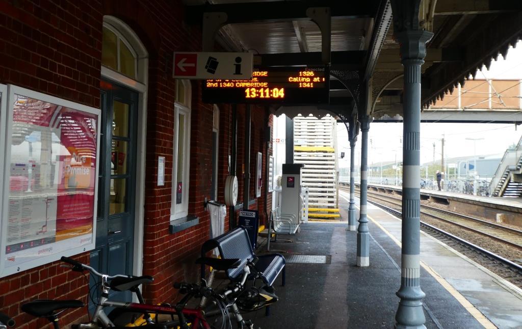 Dot-matrix displays showing next three services on each platform but not visible on entire length of platform and are partly obscured by other signage.