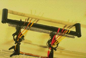 Spring Wire Breakout System Consists of harness board springs and spring holders to hold wire ends taut. When harness is removed from board, wires simply pull from spring.