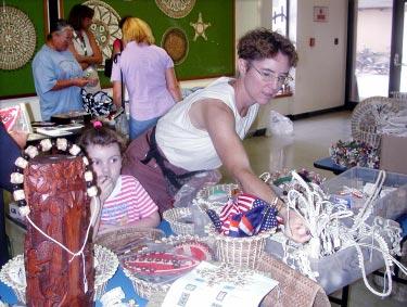 (Photo by KW Hillis) With the help of her 4-year-old daughter Audrey, Lynn Cagle looks for Christmas presents at the Mic Shop stall during Monday s Kwajalein Art Guild Fall Holiday Faire.
