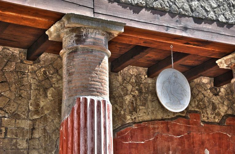 When the catastrophe of 79 AD occurred Herculaneum was submerged under a torrent of mud and lava that hardened into a soft tufa (a kind of coarse rock) that preserved many of the timber features and