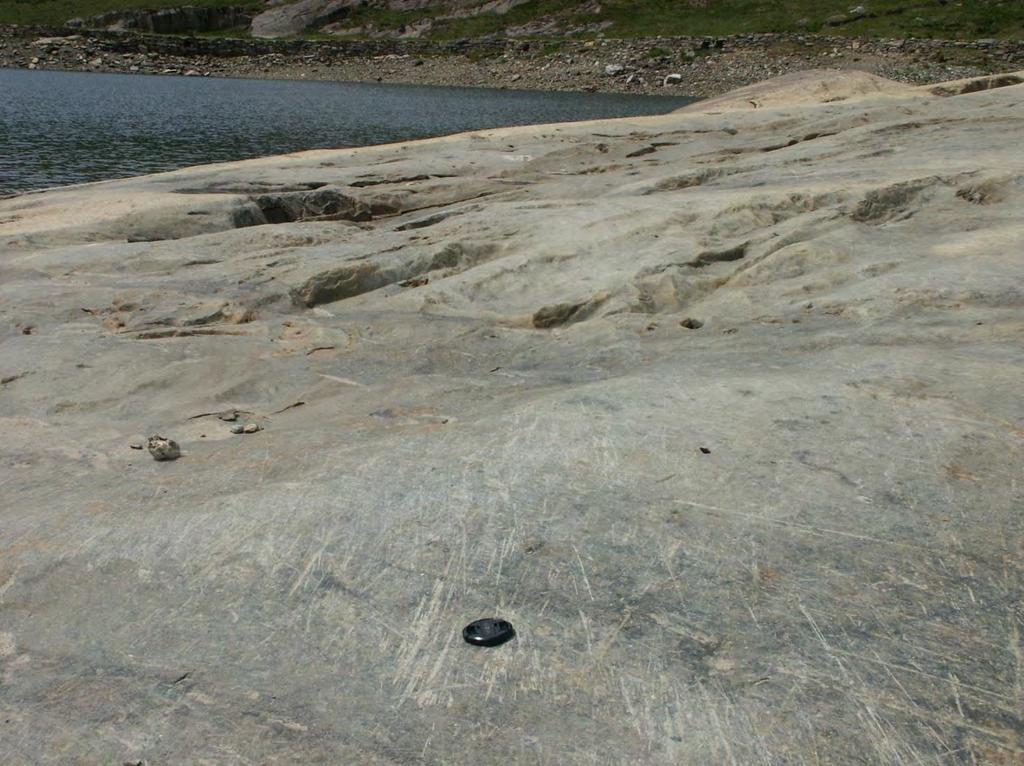 Figure 2: Striated bedrock surface in Llyn Llydaw, Snowdonia (N 53 4 23, W4 2 32 ). Note the cross-cutting nature of the striations which indicates a change in ice-flow direction. Lens cap for scale.