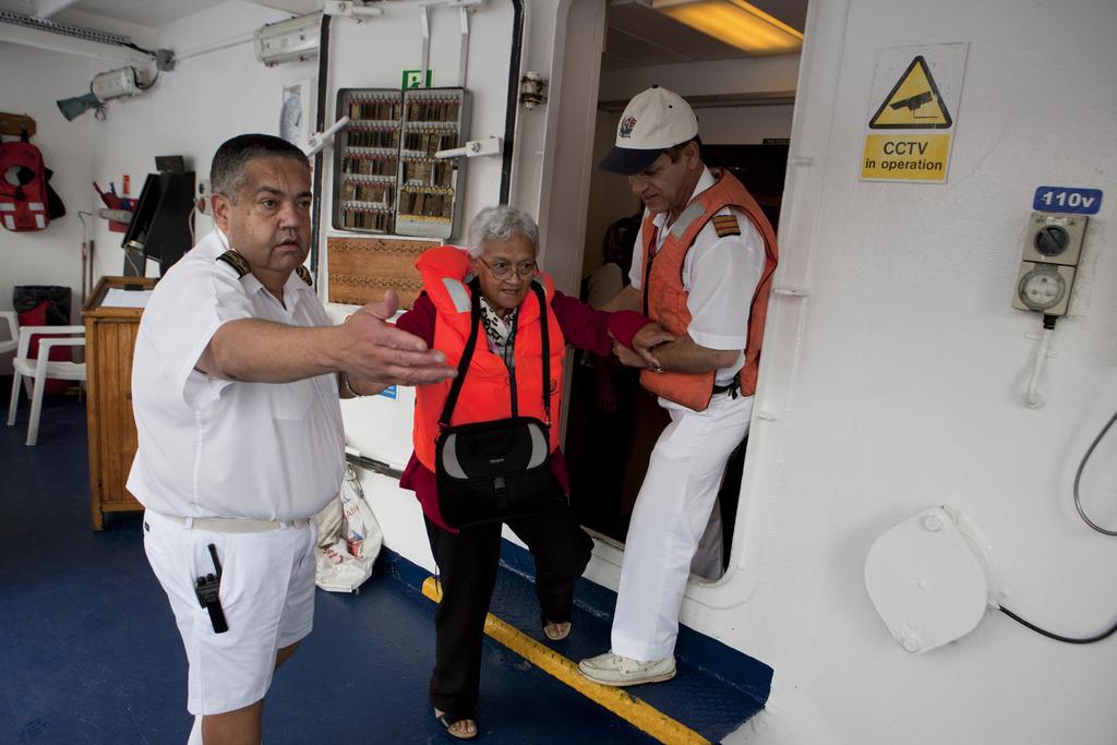 St Helena island. Captain Rodney Young, left, and doctor Revti Kaul assist an elderly passenger during disembarkation.