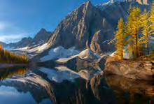 alpine scenery where jagged mountain peaks, deep-green forests, pristine lakes,