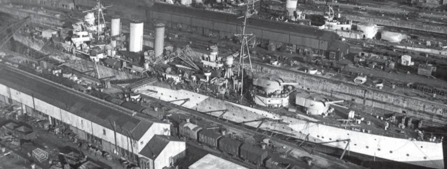 The Kent class heavy cruiser HMS Berwick undergoing a minor refit in Rosyth Dockyard on the Firth of Forth, during the late summer of 1943.