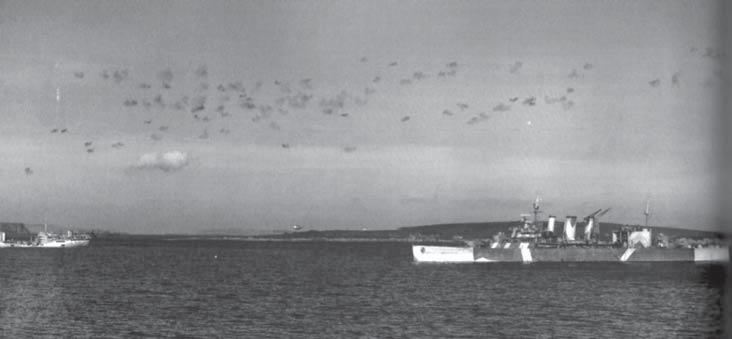 HMS Berwick in Scapa Flow, adding her weight to the flak barrage during an air defence exercise at the fleet anchorage in early 1942.