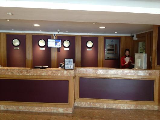 If you arrive in the lobby area from the car park by the lift, as you exit the lift turn right and go through the double doors and turn left, down the slight decline to the main reception area, the