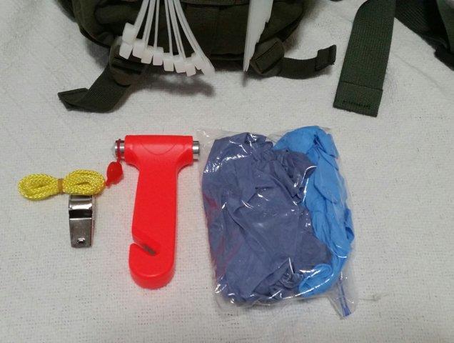 Contained in the smaller pouch on the front, at the top, are a whistle, glass breaking/strap cutting tool, and nitrile gloves.