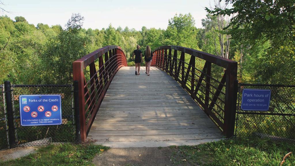 Girls enjoying a summer s day, cross the bridge into the Forks of the Credit Provincial Park above Cataract Falls.