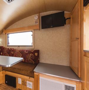 The front of the trailer offers a sink, glass-top stove, wardrobe,