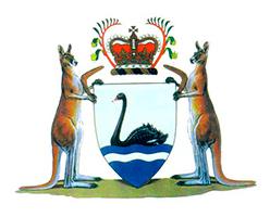The shield pictures a Black Swan on rippled water. The shield is supported by a Kangaroo on either side, each holding a Boomerang. Above the shield is a Royal Crown surrounded by Kangaroo Paw flowers.