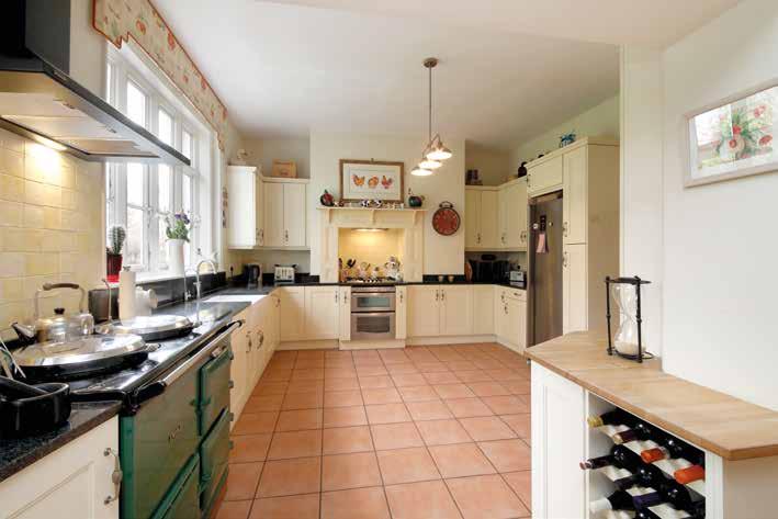 The kitchen with its AGA has an extensive range of cupboards, a fitted dishwasher, oven and hob.