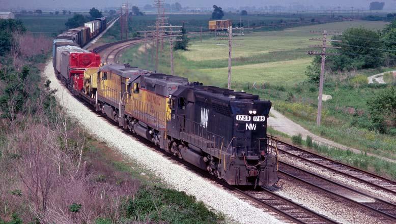 ATSF SD45 #5599 leads a westbound trailer train under Hwy 10 and into Hardin on June 5, 1982.