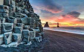 Reynisfjara Beach Reynisdrangar are basalt sea stacks situated under the mountain Reynisfjall near the village Vík í Mýrdal, southern Iceland which is framed by a black sand beach that was