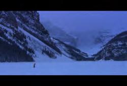 Hotel: Wide pull out on cross-country skier to reveal mountains in background (Winter)