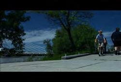330 MB-HD-001 Manitoba: Winnipeg: Provencher Bridge: Pan down from cables to children biking and people walking