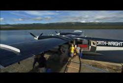 Territories: Medium wide pan of floatplane on lake leaving dock to take off