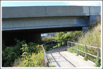 The trail consists of a concrete sidewalk from Bergey Court to the Highway 7/8 bridge, where it bends south and turns to a wide natural ground cover trail