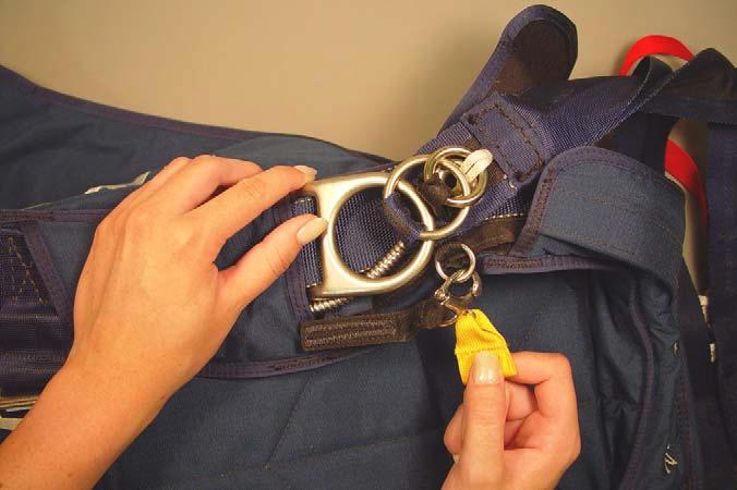 Hook the reserve lanyard shackle to the ring on the right-hand riser. 9.