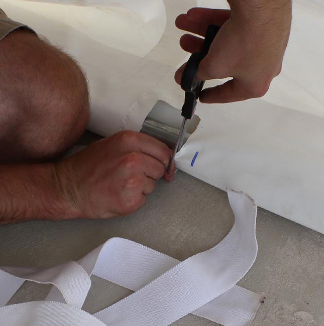 Make small cuts using a scissors in the roof cover pocket for the ratchet tie down strap to go through.