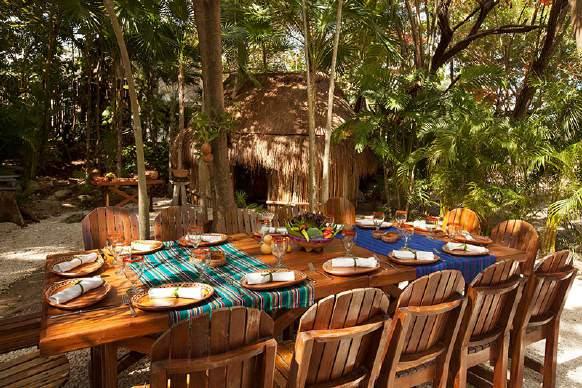 Inside, a thatched-roof hut houses a fire pit dug into the soil, where a clay pot holds and cooks the food. The chef talks through the recipe speaking the Mayan language while another chef translates.