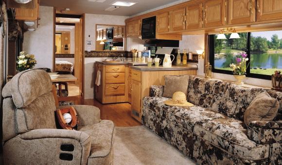 AIM FOR COMFORT AND ADVENTURE Beautiful upholstered furniture and optional wood-plank flooring enhance the expansive galley and living room.