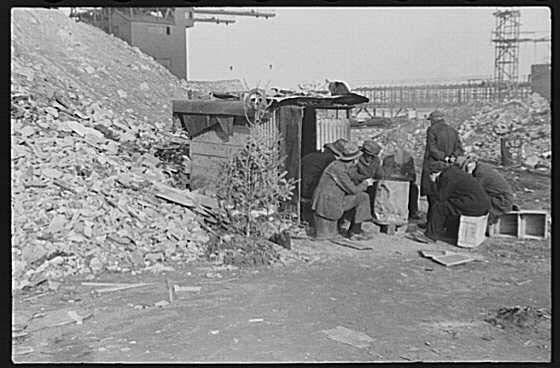 Unemployed workers in front of a shack with