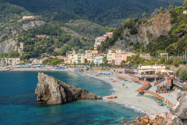 village and now a well-known luxury yacht harbor, captivates with its many pastel-colored houses, the church of Saint George on the cliff, Castello Brown, and the lighthouse at the tip.