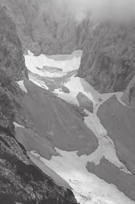 Slika 7: Miha Pavšek meri vertikalno oddaljenost stare merilne točke iz leta 1990 od površja ledenika v letu 1994, ki je pod spodnjim robom fotografije (fotografirala: Katja